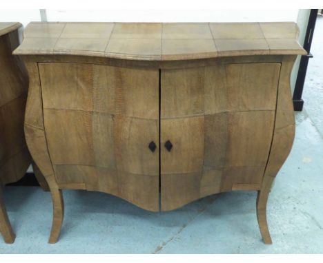 GINGER BROWN FRANCE BOMBE COMMODE, with a serpentine shaped top and two panelled doors enclosing a shelf, 120cm W x 96cm H x 