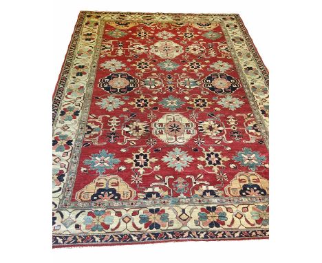 KAZAK CARPET, 340cm x 253cm, of polychrome and ivory palmettes on ruby field.