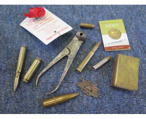 An assorted bag of interesting militaria as follows: Trench art lighter and match case, pincer mould, U.S. Poppy, A/F badge &