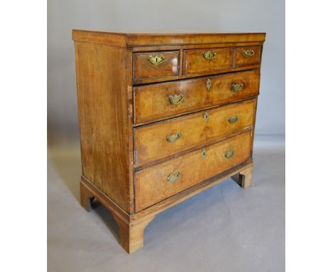A George II Walnut Chest of Three Short and Three Long Drawers with brass handles and escutcheons raised upon bracket feet, 9