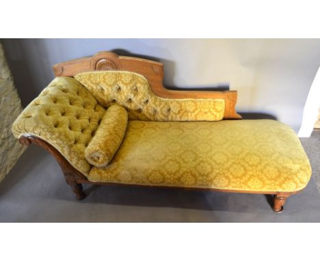 A Victorian Walnut Chaise Longue with a button scroll end raised upon tapering legs