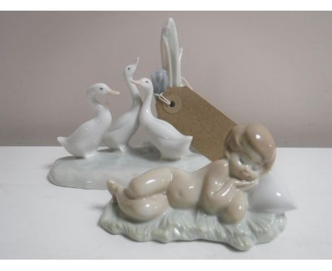 A Lladro figure of a sleeping baby, together with a Nao figure of geese