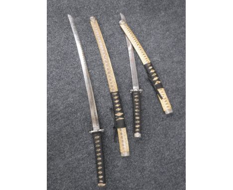 An Indian sword together with two Japanese style samurai swords and a hand axe