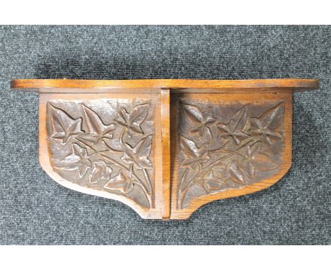 An Arts &amp; Crafts carved oak wall bracket CONDITION REPORT: 51cm wide by 25cm high by 16cm deep. Some losses and splits to