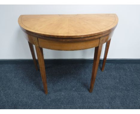 An inlaid walnut demi lune turnover top card table 