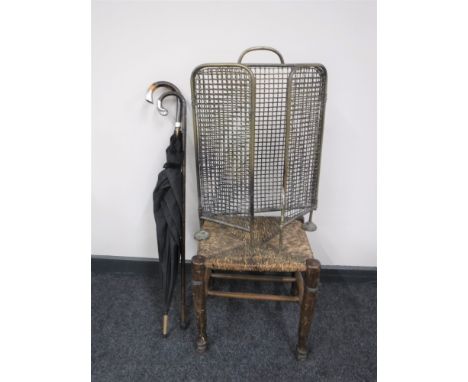 A brass fire guard, together with a rush seated stool, a silver handled cane and a silver handled umbrella