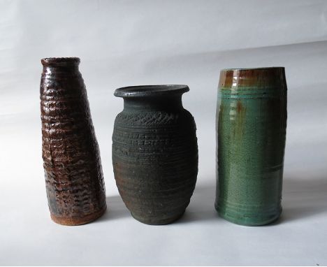 DENISE WREN (1891 - 1979):A textured vase with dark matte green glaze and a tapering similar vase with treacle glaze. Both wi