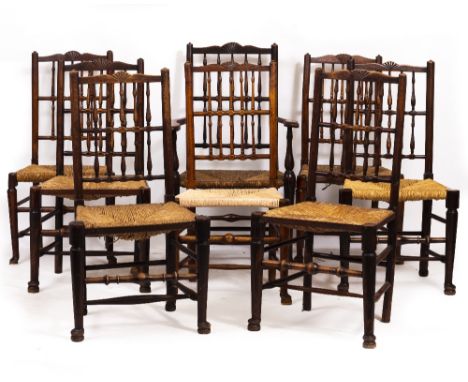 A GROUP OF SIXTEEN MATCHED NORTH COUNTRY SPINDLE BACK DINING CHAIRS with rush seats and club feet, a pair of carver chairs an