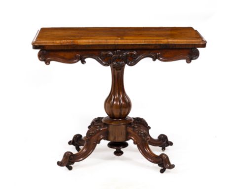A VICTORIAN ROSEWOOD FOLD OVER CARD TABLEwith circular baize inset surface within, carved scrolling decoration to the frieze 