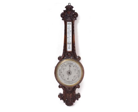 AN EDWARDIAN CARVED OAK CASED ANEROID WHEEL BAROMETER having a silvered dial and mercury tube thermometer, 85cm high Conditio