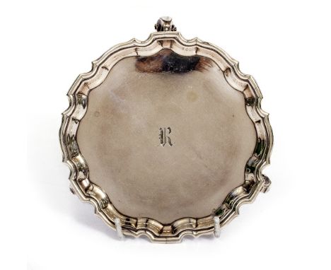 A SMALL GEORGE II SILVER SALVER OR STAND with piecrust edge and scroll feet, later engraved with initial R, makers mark of De