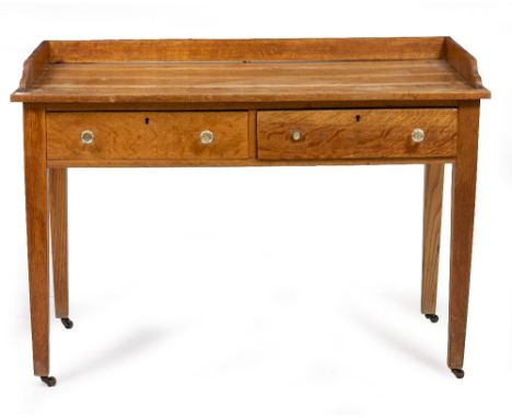 AN OAK SIDE TABLE with galleried back and sides, square tapering legs and casters, with two frieze drawers, 122cm wide x 60.5