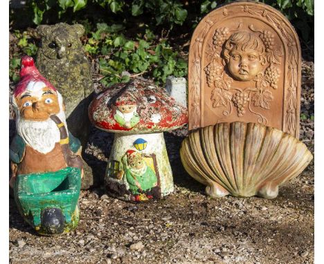 A PAINTED AND CAST RECONSTITUTED STONE GARDEN ORNAMENT  in the form of a toadstool, the home to two gnomes, 25cm diameter x 3