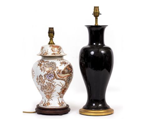 A BLACK GLAZED POTTERY TABLE LAMP AND CORAL SHADEin the form of a baluster vase with gilt plinth base, 16cm wide x 52cm high 