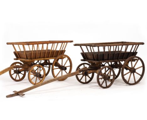TWO SIMILAR OLD WOODEN HAND CARTS with iron bound splaying tops and pivoted front axles with handlebar,one cart possibly olde