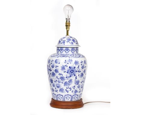 A CONTEMPORARY TABLE LAMP in the style of a Oriental blue and white ginger jar, on a turned wooden base, 22cm diameter x 50cm