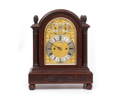 AN EARLY 20TH CENTURY GEORGIAN STYLE MAHOGANY CASED BRACKET OR TABLE CLOCK with arching case and carved and turned finials, f