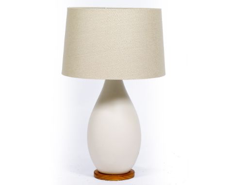 AN EGGSHELL GLAZED OVOID TABLE LAMP on a circular pine base, 27cm wide x 76cm high At present, there is no condition report p