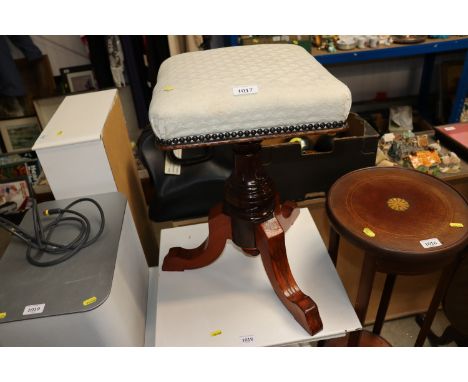 A mahogany revolving piano stool raised on tripod base