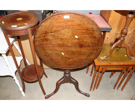 An antique mahogany circular snap top table raised on tripod base