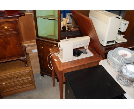 A Singer sewing machine in fitted table, sold as collectors item