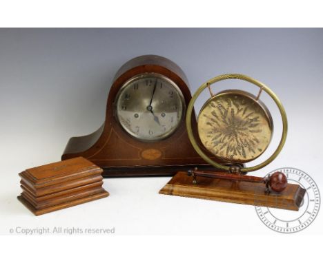 An Edwardian table gong on a mahogany base, 24cm high, an oak money box, 16cm wide, and an inlaid mantel clock 41cm wide (3)