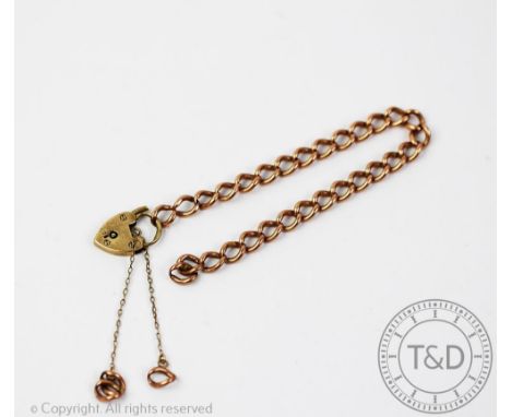A 9ct rose gold slender curb link bracelet with an attached padlock clasp, gross weight 12.6gms 