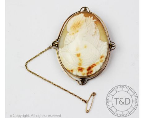 A 9ct gold mounted cameo brooch depicting day and night, 6.5cm overall including mount 