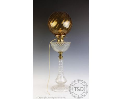 A Victorian cut glass oil lamp, with brass fittings, on circular base, with an associated amber coloured glass shade, 72cm hi