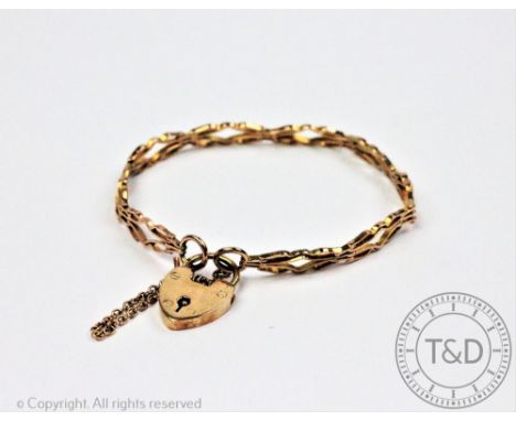 An early 20th century yellow metal delicate link bracelet, designed as nine uniform shaped panels, with attached 9ct gold pad