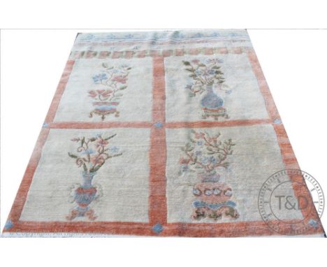 A Chinese wool carpet, worked with four panels of vases of flowers, 188cm x 156cm CONDITION REPORT: The carpet is lightly gru