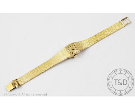 A ladies Longines 9ct gold wristwatch 1979, he cushion shaped face with gilt dial, black batons and attached integral 9ct gol