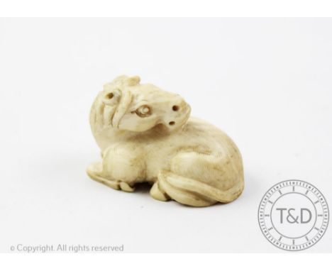 A carved ivory netsuke, Meiji Period (1868-1912), in the form of a recumbent horse, signed to the underside, 5cm wide  CONDIT