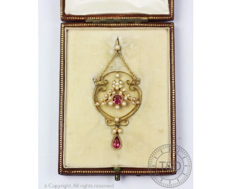 An early 20th century tourmaline and seed pearl set pendant within fitted case, designed as a yellow gold scroll surround wit