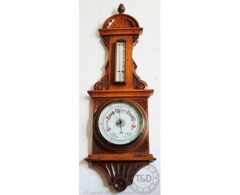 An Edwardian carved golden oak aneroid barometer, 77cm, with a carved oak wheel barometer (2) (Both at fault) CONDITION REPOR