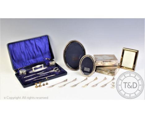 A cased silver manicure set, Chester 1920, to include, silver topped jars, buffers, tools, two silver photograph frames, a Go