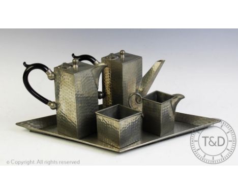 An Art Deco planished pewter tea service comprising; a tea pot, 15cm high, hot water jug, 15cm high, a milk jug and sugar bow