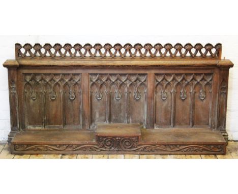 A late 19th century carved oak ecclesiastical panel, with two 'spires' to either side, and split level shelf, 143cm H x 174cm