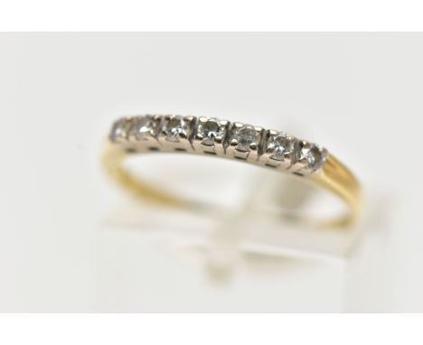 A YELLOW METAL DIAMOND HALF ETERNITY RING, set with a row of seven round brilliant cut diamonds, each in a shared claw settin