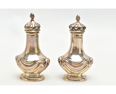 A PAIR OF EARLY 20TH CENTURY SILVER PEPPERETTES, bell shaped pots, each detailed with an embossed swag design, long stem, fit