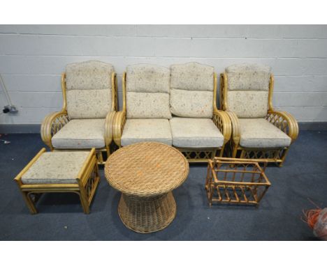 A WICKER FOUR PIECE CONSERVATORY SUITE, comprising a two seater sofa, two armchairs, and a foot stool, along with a circular 