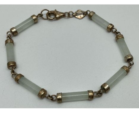 A silver and pale green jade bracelet with lobster style clasp. Bracelet made from 7 small cylinder shaped jade beads each ca