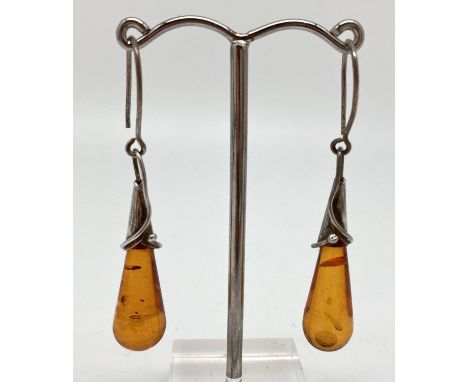 A pair of white metal and cognac amber Art Nouveau design drop earrings. With hooked wires, drop approx. 4cm. 