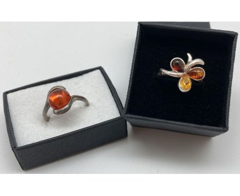 2 silver and amber set dress rings. A modern twist design mount set with a round cabochon of cognac amber together with a but