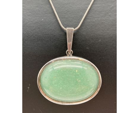 An oval shaped Jade pendant in 925 silver mount, on a 16" silver snake chain. Pendant bale, lobster claw clasp and joining li