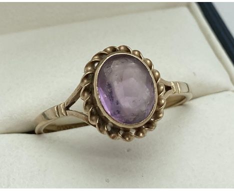 A 9ct gold and amethyst dress ring. A single oval cut amethyst with rope detail to mount. Ring size T. Total weight 2.2g. 