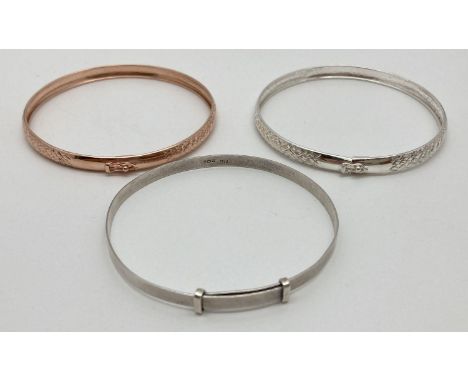 3 silver bangles. Modern design silver and rose gilt matching patterned bangles with push clasps and safety clips, together w