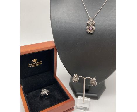 3 pieces of silver, marcasite set jewellery. A pair of large stud style earrings with amethyst set flower decoration, a leaf 