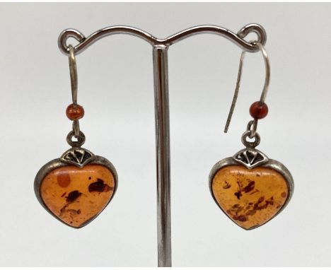 A pair of white metal and cognac amber drop style heart shaped pendants and amber bead detail to hooks. Approx. 3cm long. 