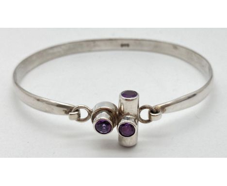 A 925 silver bangle with hinged contemporary style finial set with 4 amethyst stones. Approx. 7cm x 6cm. Stamped STG inside b